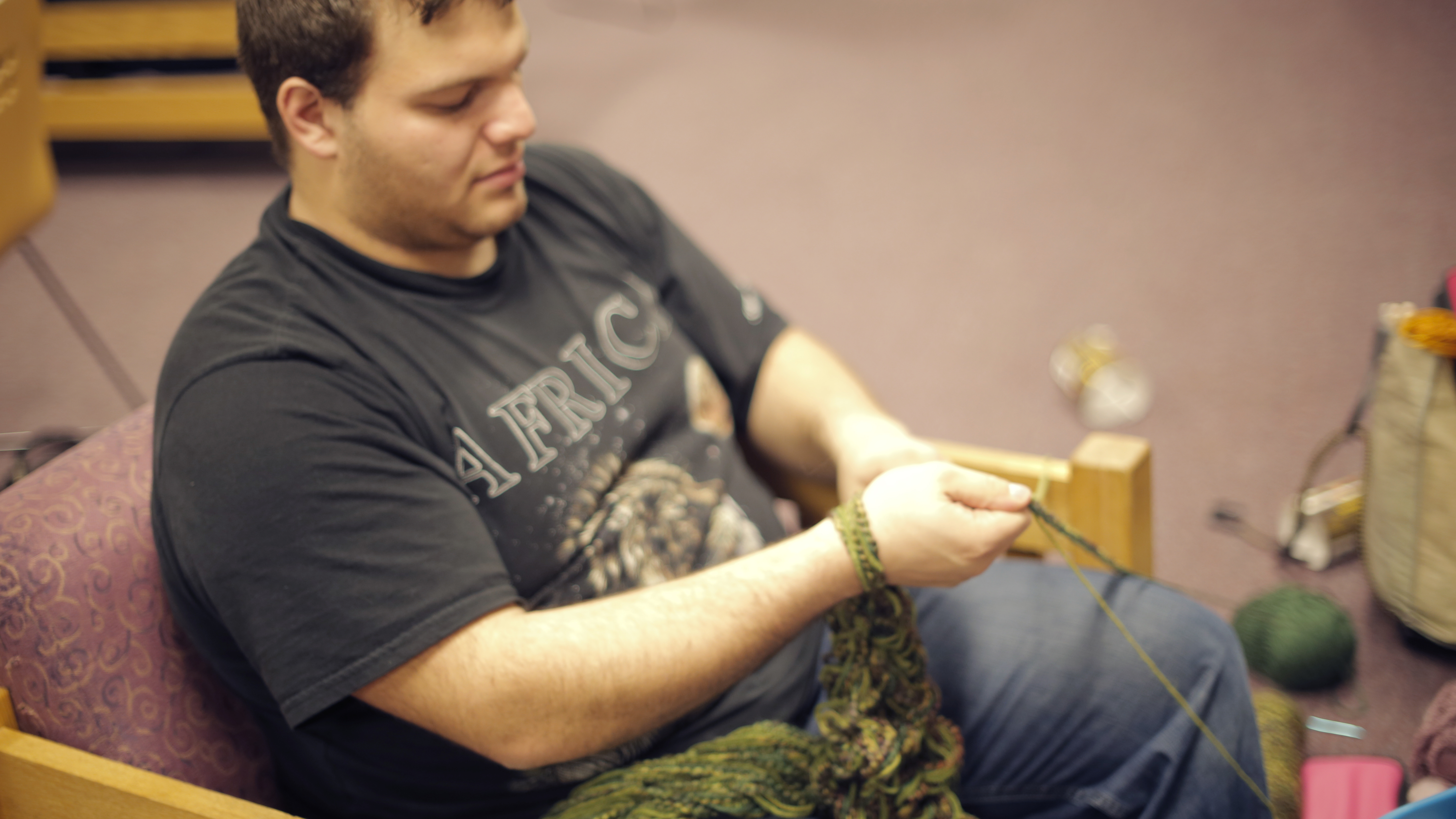 A Knitting Club member knitting with his arm