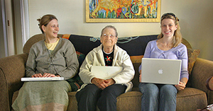 A photo of three generations of women each holding a laptop