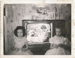 An old photo of two girls on either side of a television