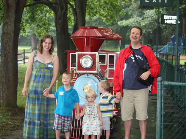 author with children and husband in front of train