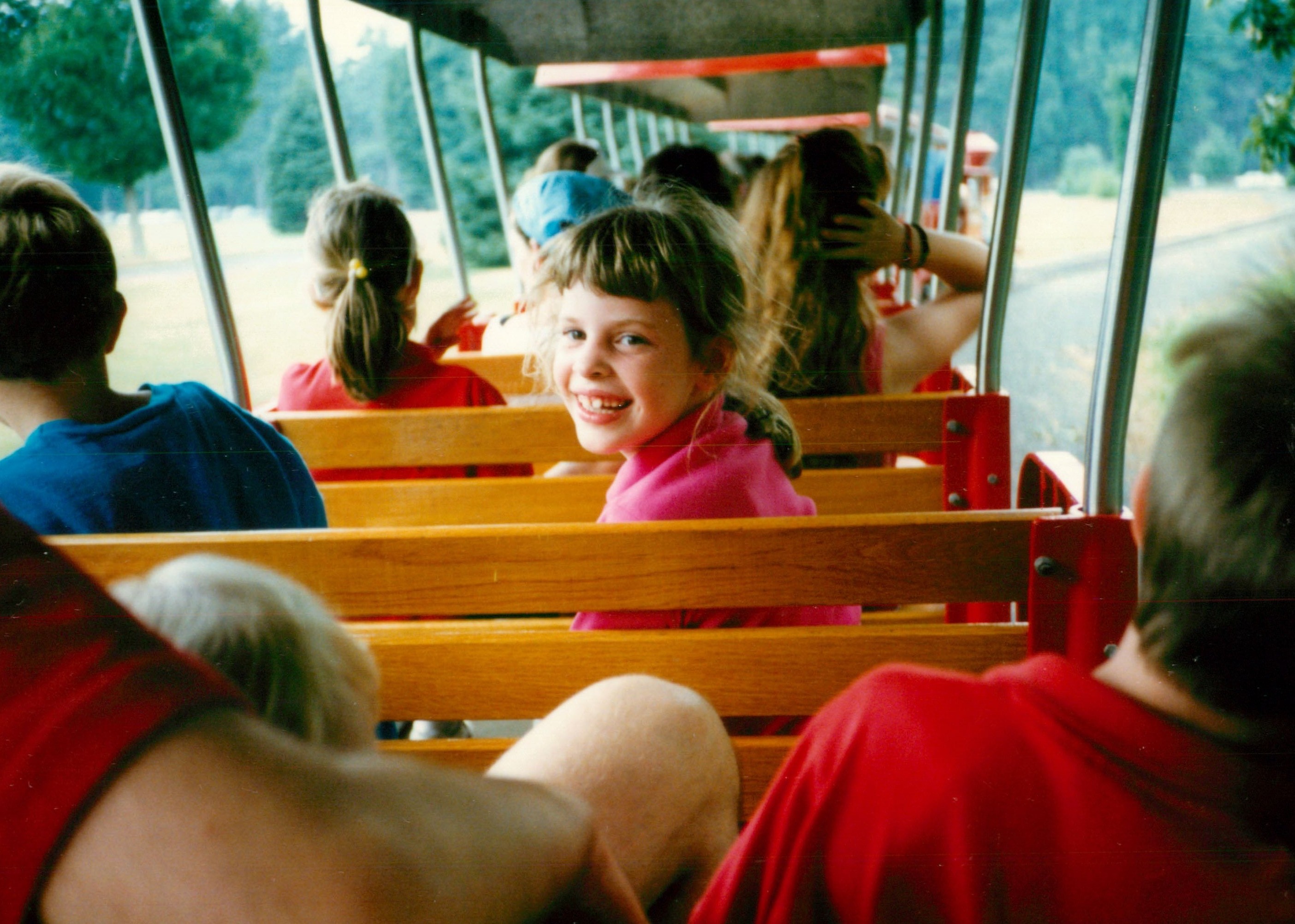 young girl on train looking over shoulder at camera